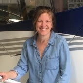 Woman in blue shirt standing in front a plane